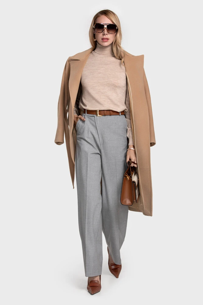 Camel wool coat over a beige turtleneck with grey wide-leg trousers