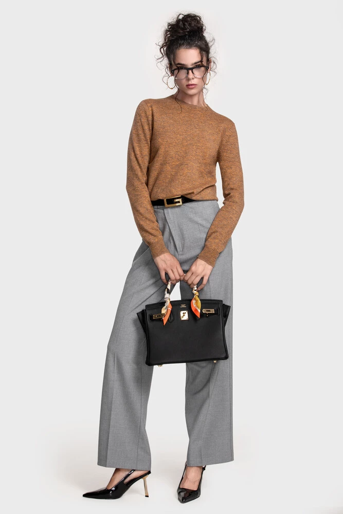 Amber marled crewneck sweater with grey wide trousers and a black structured handbag