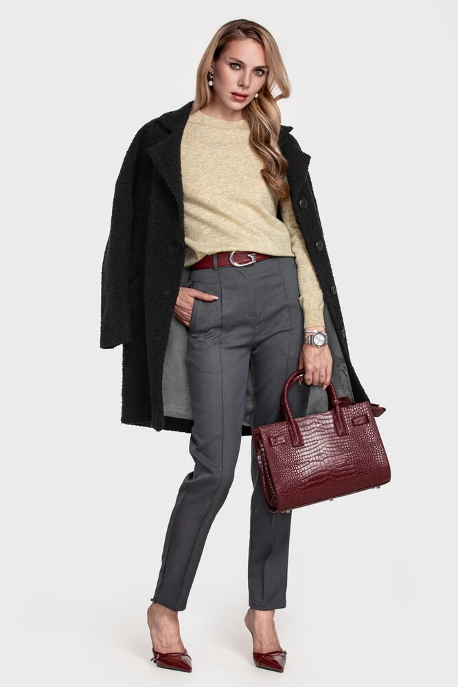 Black bouclé coat over a butter-yellow sweater with grey cigarette trousers and a burgundy bag