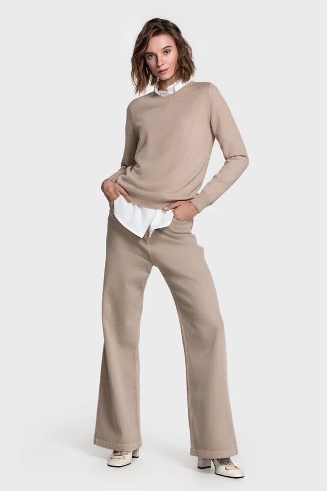 Head-to-toe sand-toned look with a beige sweater over a white shirt and wide beige trousers